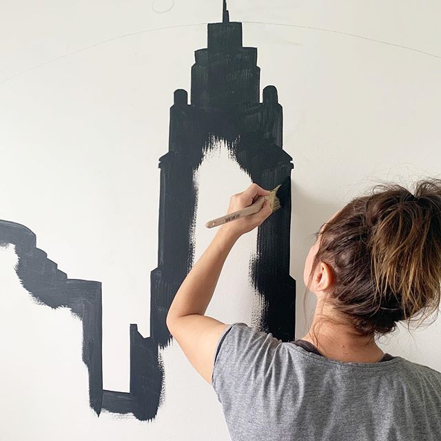 Sarah from Nestrs paints the Columbus skyline on the wall to create an experience for her guests.