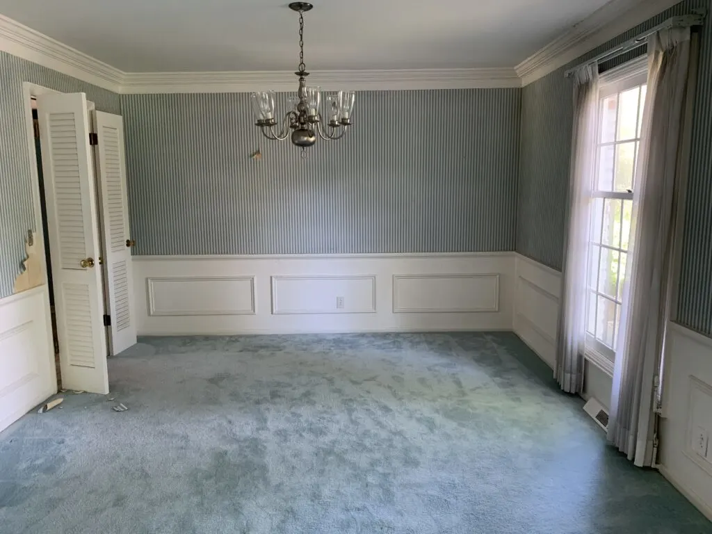 The formal dining room with blue carpet.