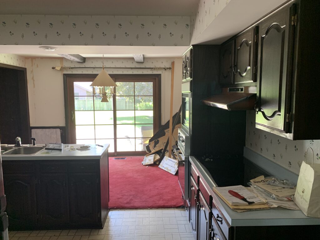 The eating area in the kitchen with red carpet and wallpaper
