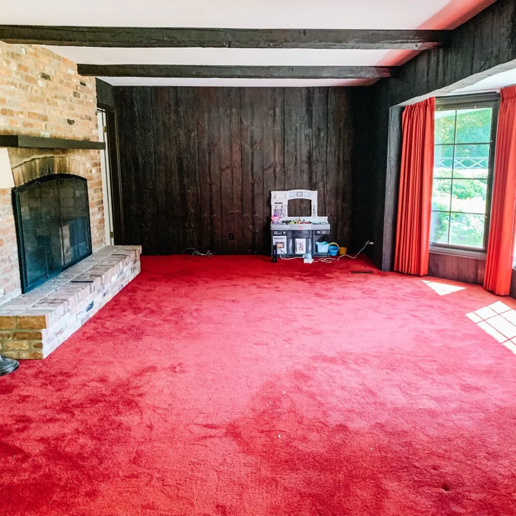 The back den, family room with red carpet and faux wood walls.