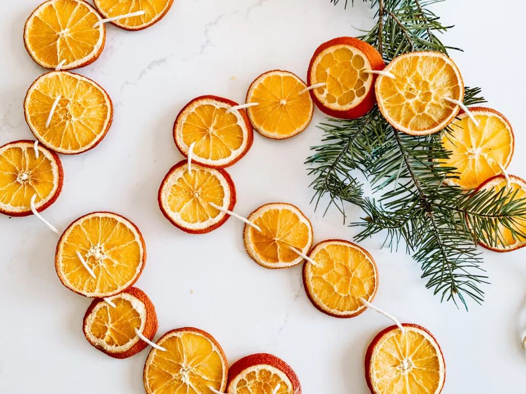 Create dried orange garland for an inexpensive way to decorate for the holidays | Building Bluebird #driedoranges #orangegarland #christmasdecor