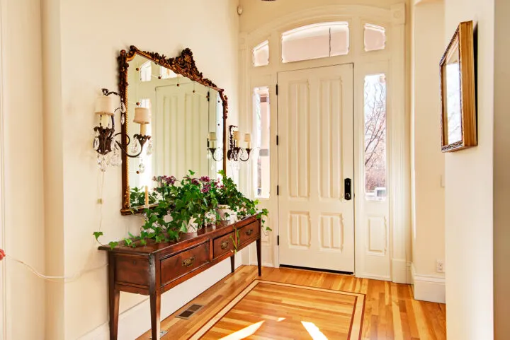 Restored foyer of the Bosler House in Denver with grand staircase and antique chandelier