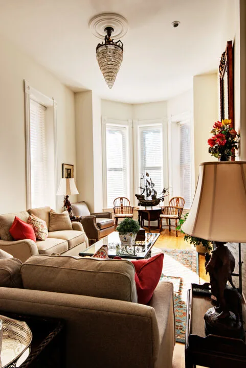 Restored living room in the Bosler House with marble fireplace, hardwood floors, and antique chandelier
